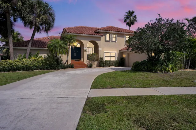 a front view of a house with a garden and yard