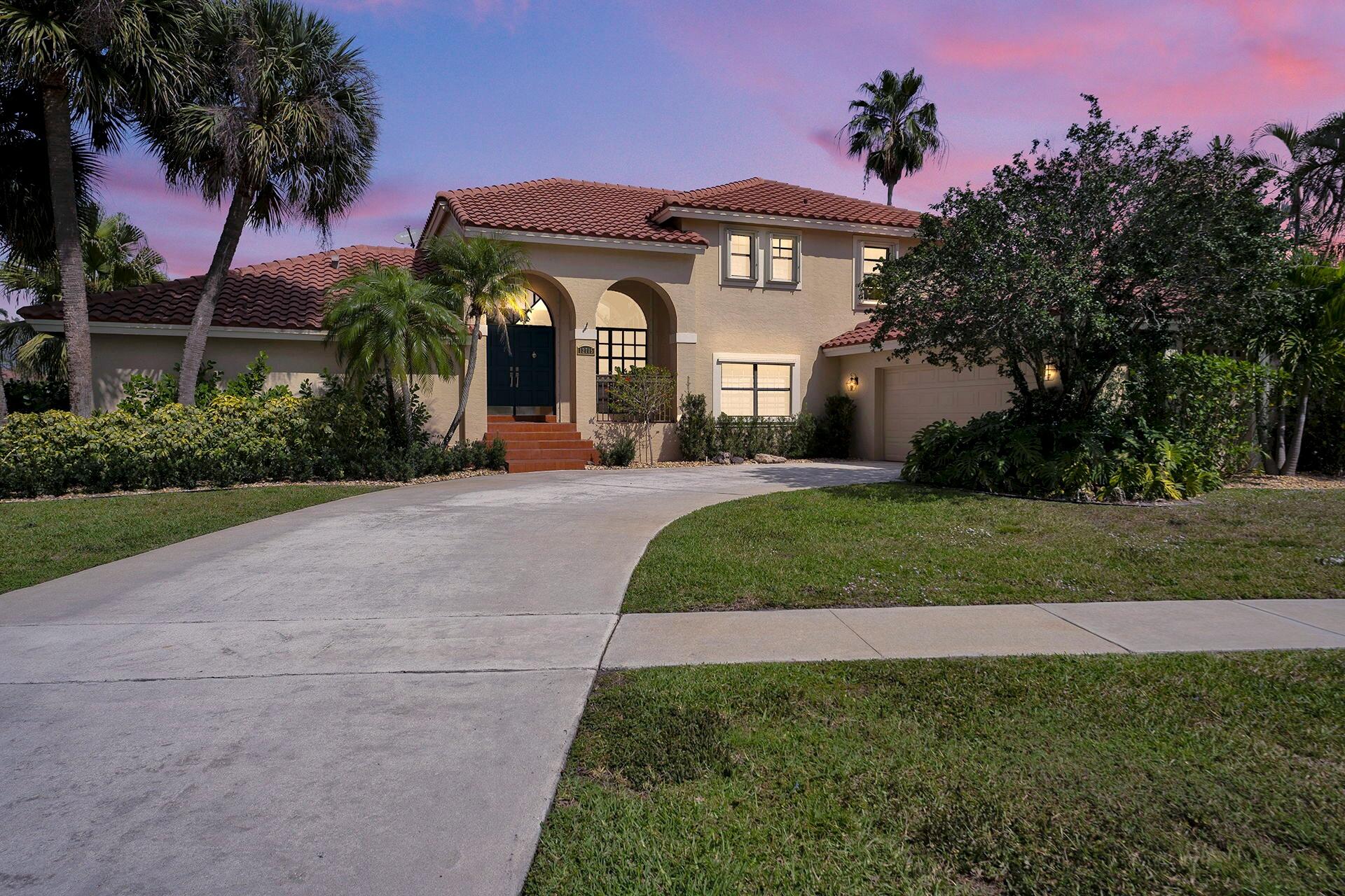 12715 Kingsway Road Wellington, FL 33414 - Photo 3 of 36 a front view of a house with a garden and yard