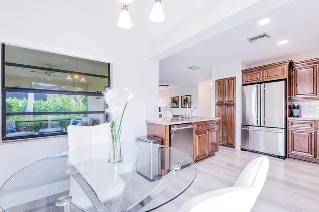a kitchen with kitchen island wooden cabinets and refrigerator