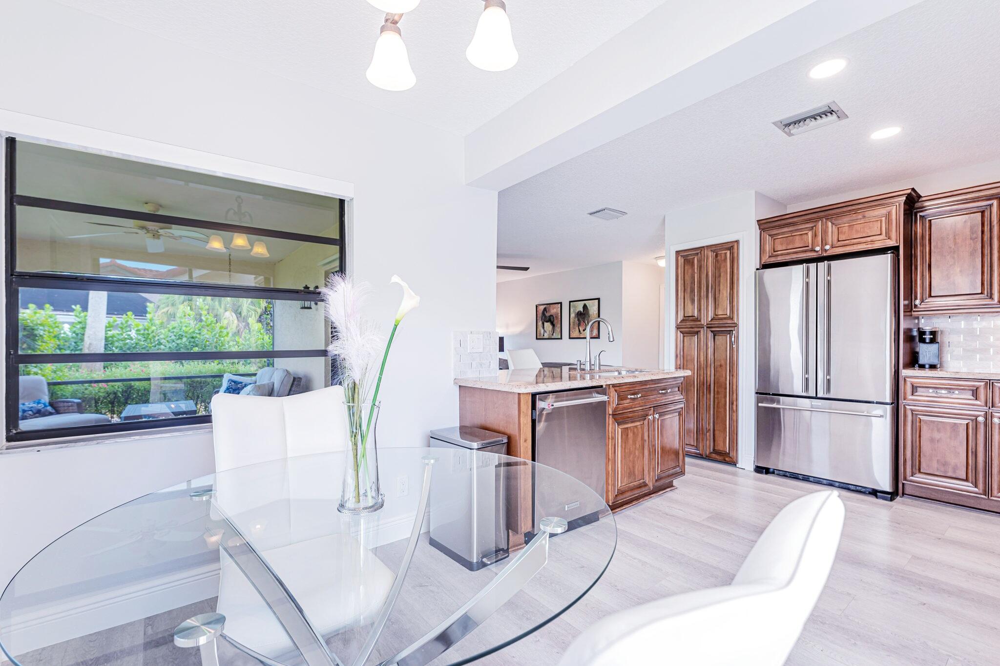 12715 Kingsway Road Wellington, FL 33414 - Photo 8 of 36 a kitchen with kitchen island wooden cabinets and refrigerator
