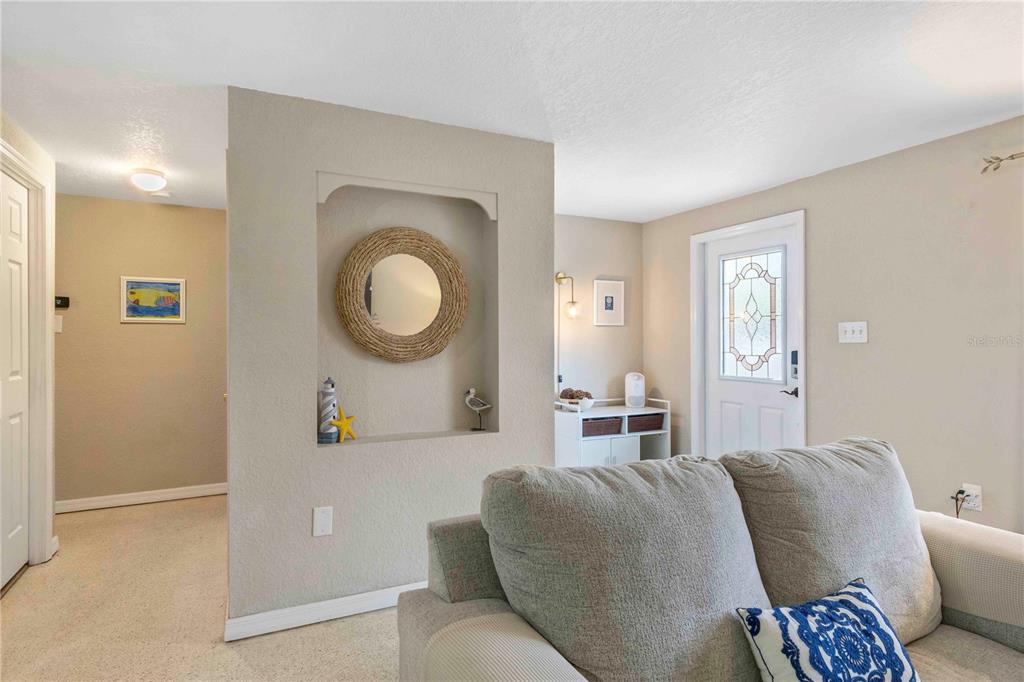 333 Hile Lane Punta Gorda, FL 33982 - Photo 13 of 72 a living room with furniture a mirror a lamp and a large window