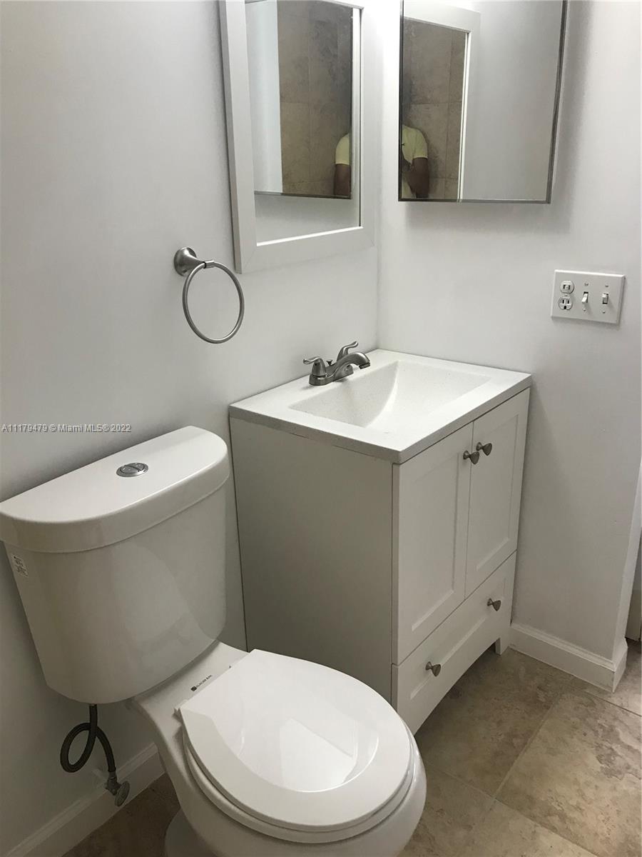 4172 Inverrary Drive, Unit 101 Lauderhill, FL 33319 - Photo 17 of 32 a white toilet sitting next to a bathroom sink