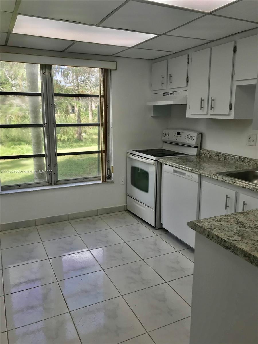 4172 Inverrary Drive, Unit 101 Lauderhill, FL 33319 - Photo 7 of 32 a kitchen with a stove a sink and a refrigerator