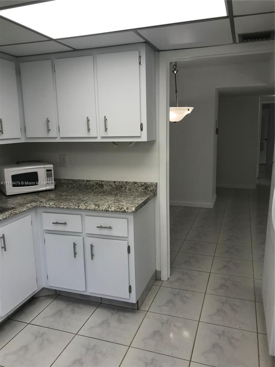 4172 Inverrary Drive, Unit 101 Lauderhill, FL 33319 - Photo 8 of 32 a kitchen with granite countertop white cabinets and granite counter tops