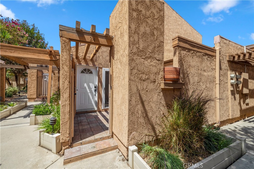 a pathway of a house with potted plants