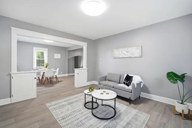 a living room with furniture a dining table and a potted plant