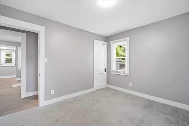 an empty room with windows and closet