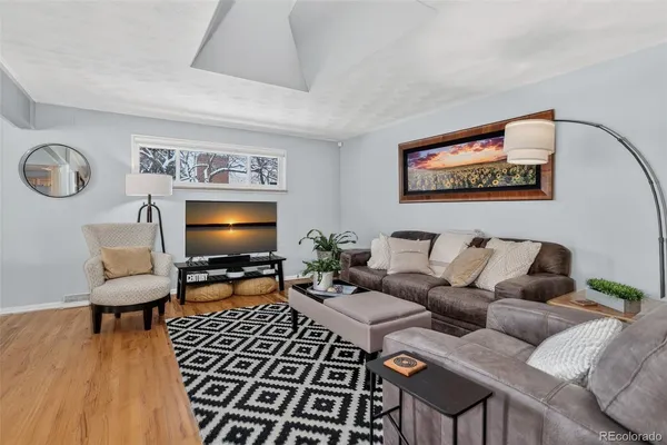 a living room with furniture and a wooden floor