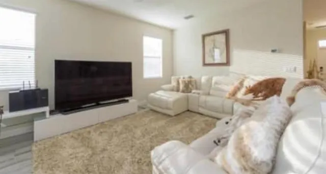 a living room with furniture and a flat screen tv