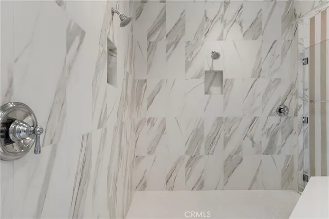 an empty room with wooden floor chandelier and windows