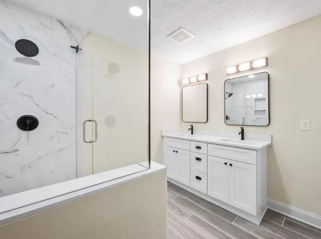 a bathroom with double vanity sinks and a mirror