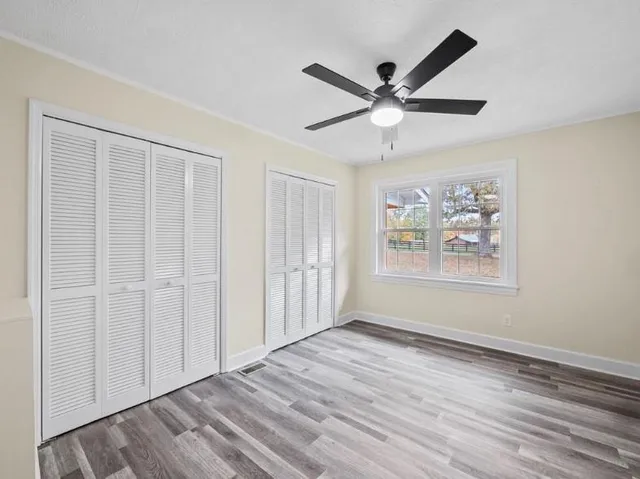 a view of a big room with wooden floor and a ceiling fan