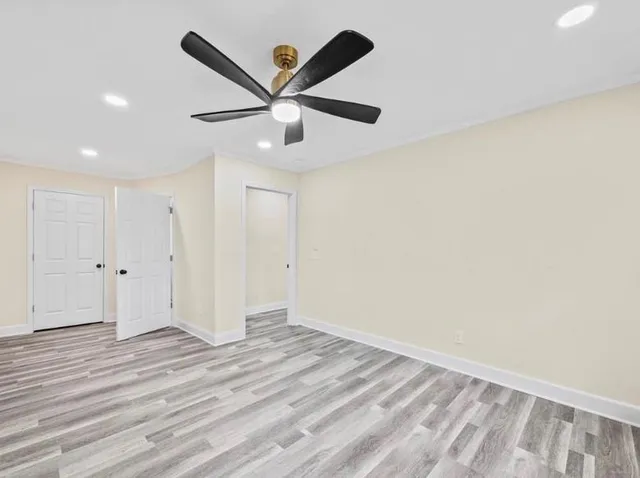 a view of a big room with wooden floor and windows