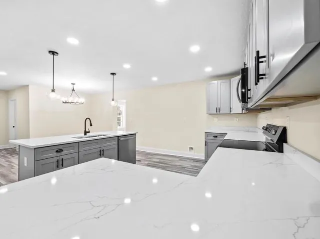 a view of a kitchen with wooden floor and stainless steel appliances
