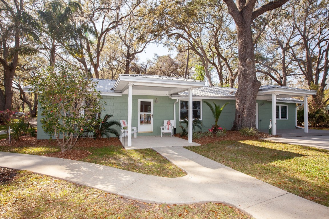 96153 Noeta Place Yulee, FL 32097 - Photo 4 of 24 a view of a house with backyard sitting area and swimming pool