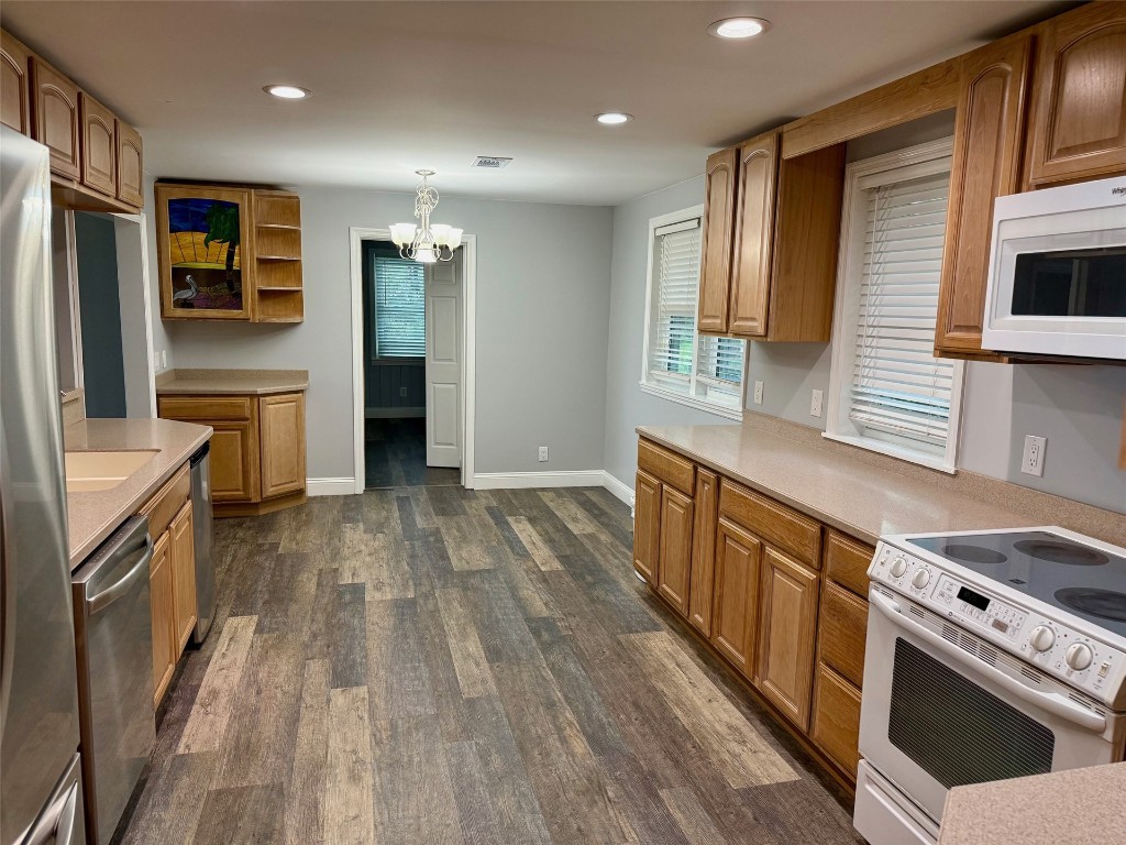 96153 Noeta Place Yulee, FL 32097 - Photo 6 of 24 a kitchen with stainless steel appliances a stove top oven a sink a refrigerator white cabinets and wooden floor