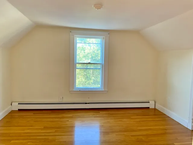 a view of a room with wooden floor and a window