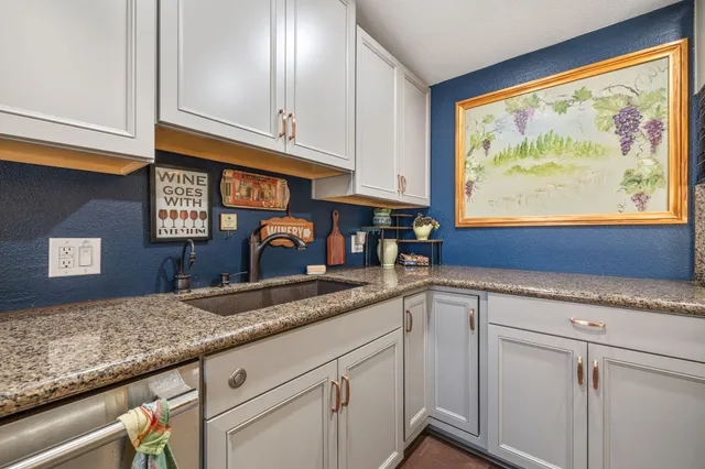 a kitchen with granite countertop stainless steel appliances a sink and cabinets