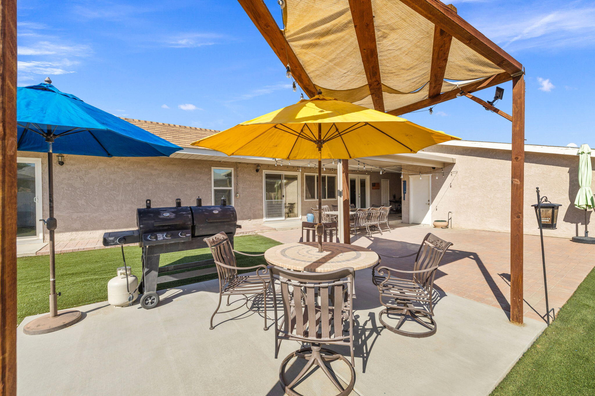 47800 Madison Street, Unit 79 Indio, CA 92201 - Photo 9 of 31 a view of a patio with a table and chairs under an umbrella