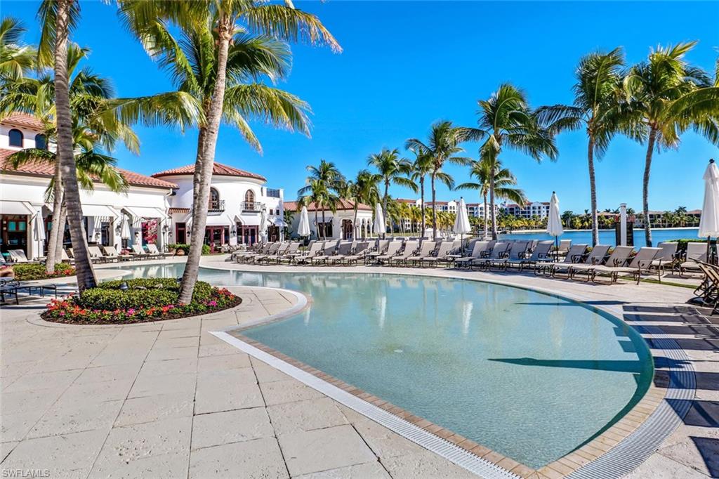 17818 Modena Road Miromar Lakes, FL 33913 - Photo 8 of 21 a view of a swimming pool with a lawn chairs under palm trees