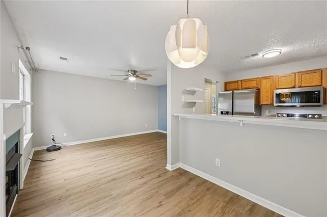 a view of a kitchen with stainless steel appliances a wooden floor