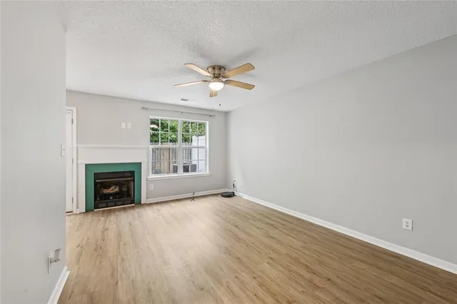 wooden floor fireplace and windows in an empty room