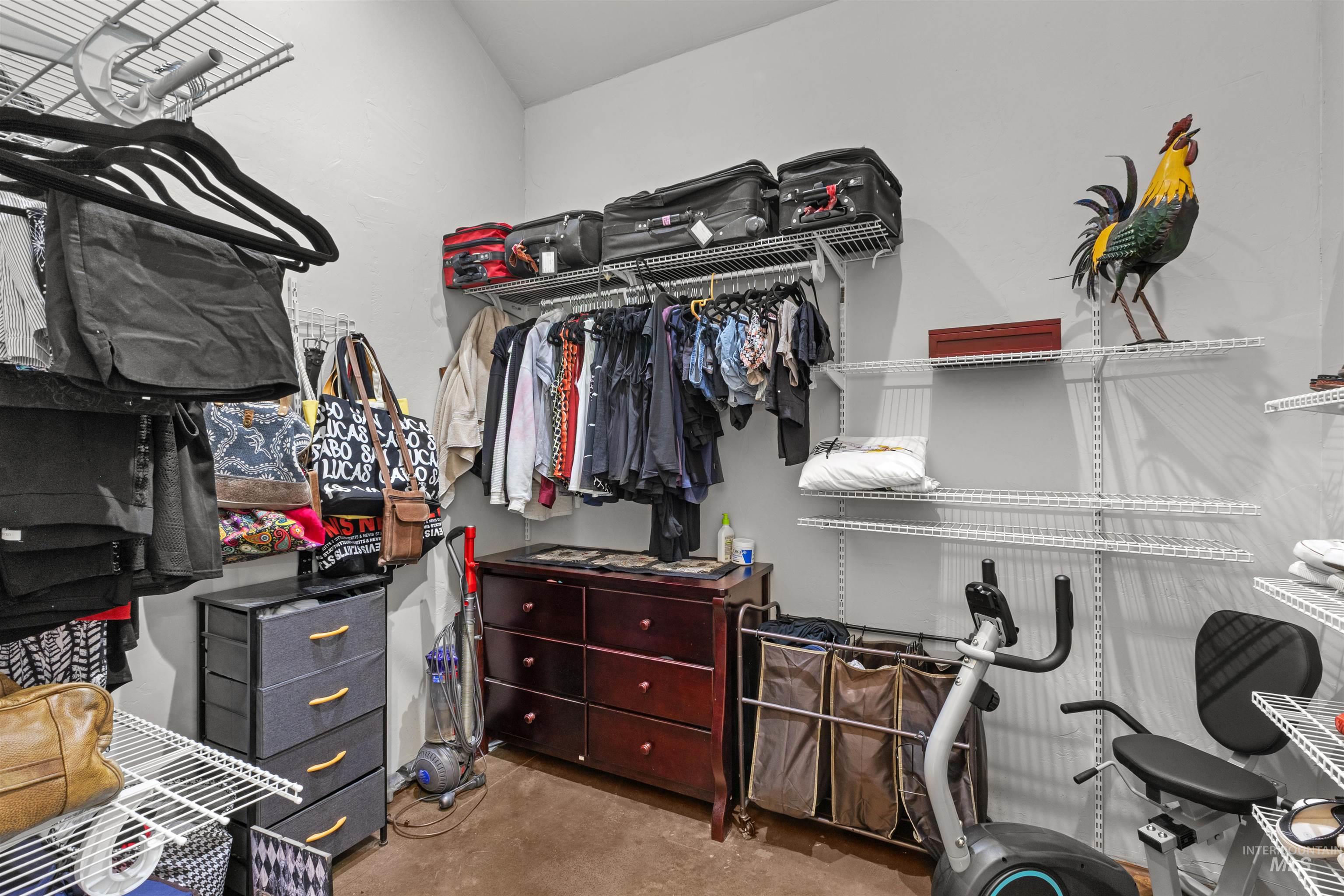 1030 Desert Glen Road Adrian, OR 97901 - Photo 34 of 47 Walk-in closet featuring extensive wire shelving, multiple hanging rods, durable carpeting, and a built-in chest of drawers