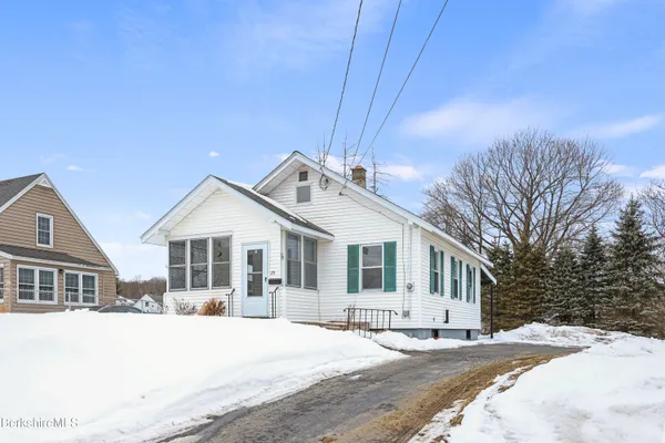a front view of a house with a yard covered in snow