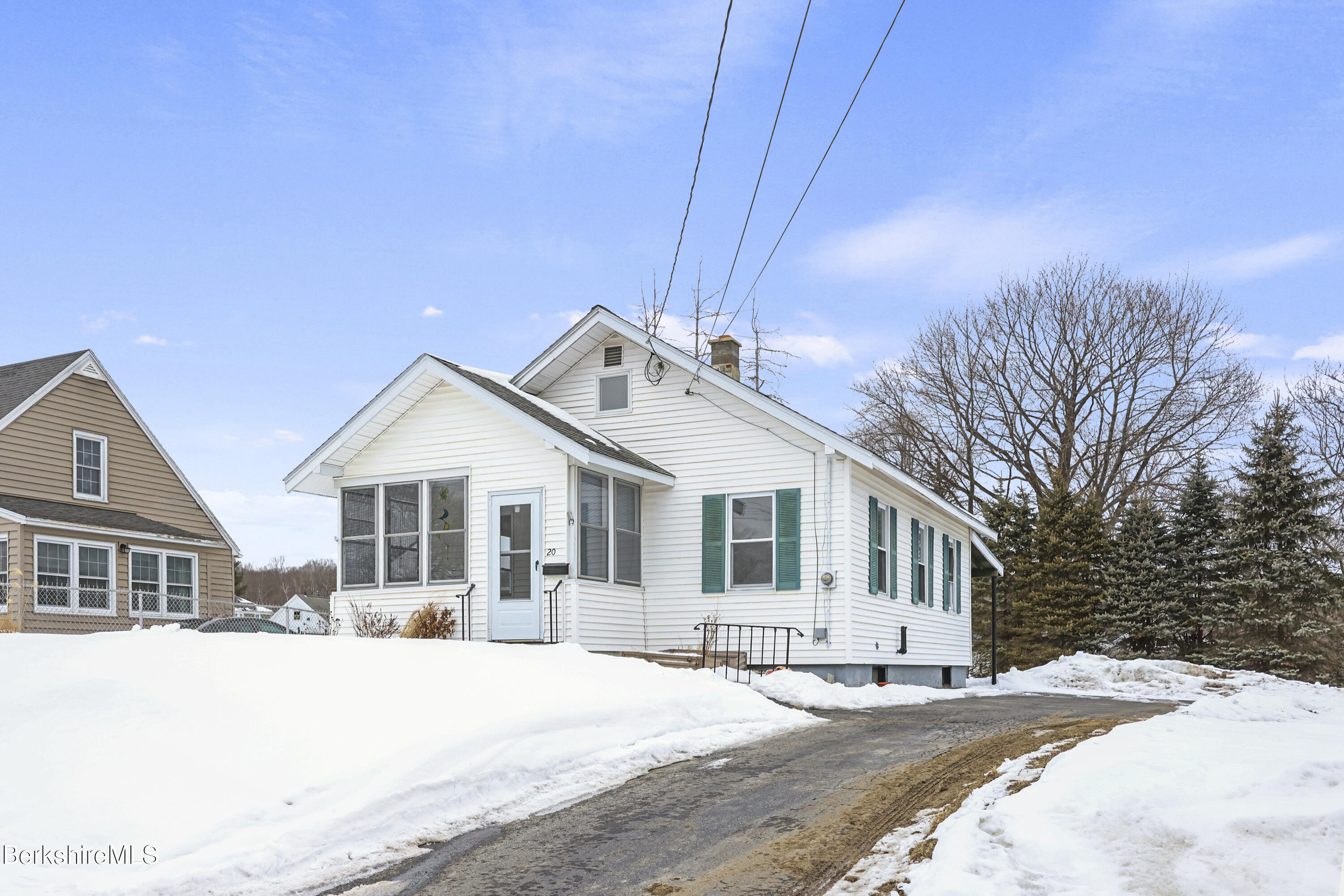 a front view of a house with a yard covered in snow