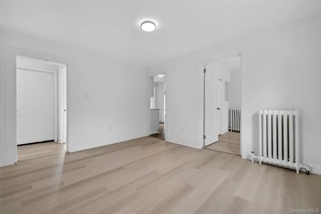 an empty room with wooden floor and a window