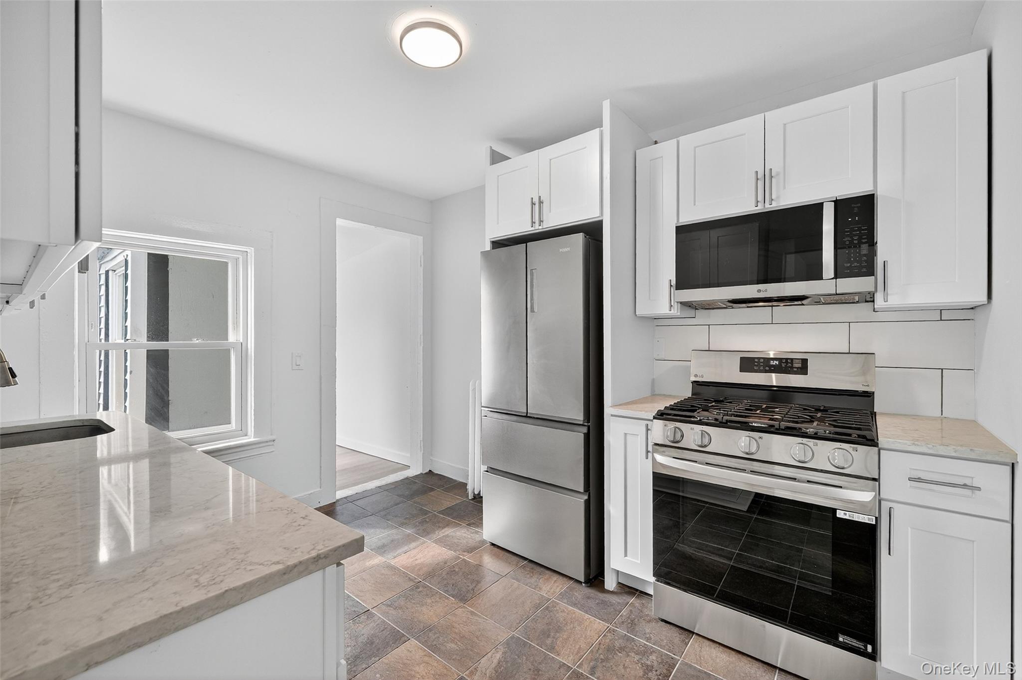 23 Ann Street, Unit 2 Ossining, NY 10562 - Photo 16 of 23 a kitchen with granite countertop a stove microwave and refrigerator