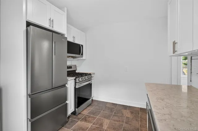 a kitchen with granite countertop a refrigerator and a stove