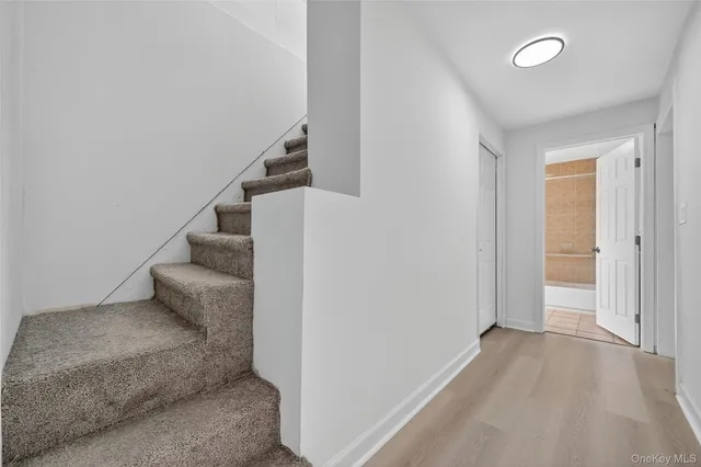 a view of entryway and hall with wooden floor