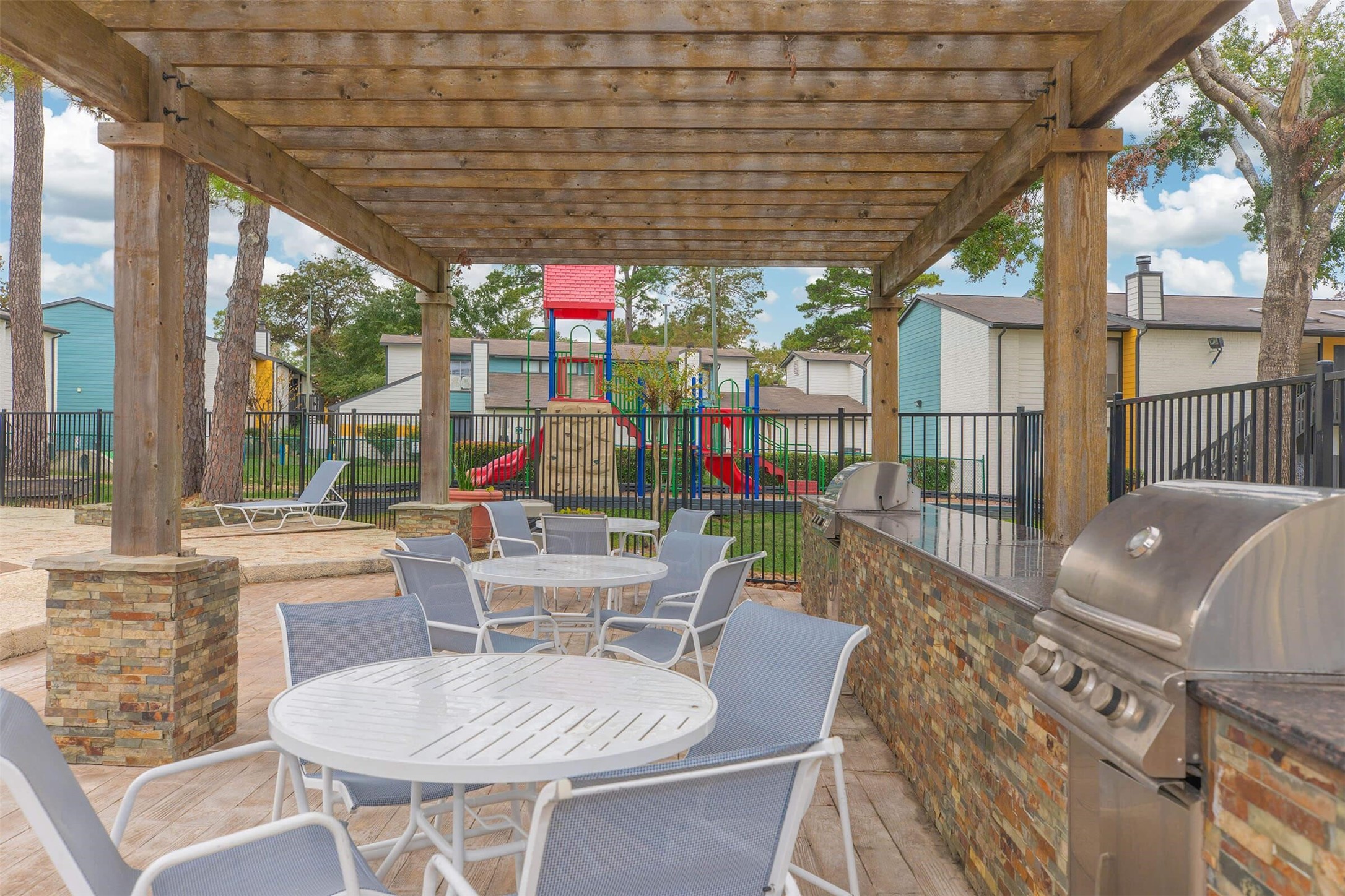 21717 Inverness Forest Boulevard, Unit 1503 Houston, TX 77073 - Photo 14 of 33 a view of a patio with a dining table and chairs with wooden floor