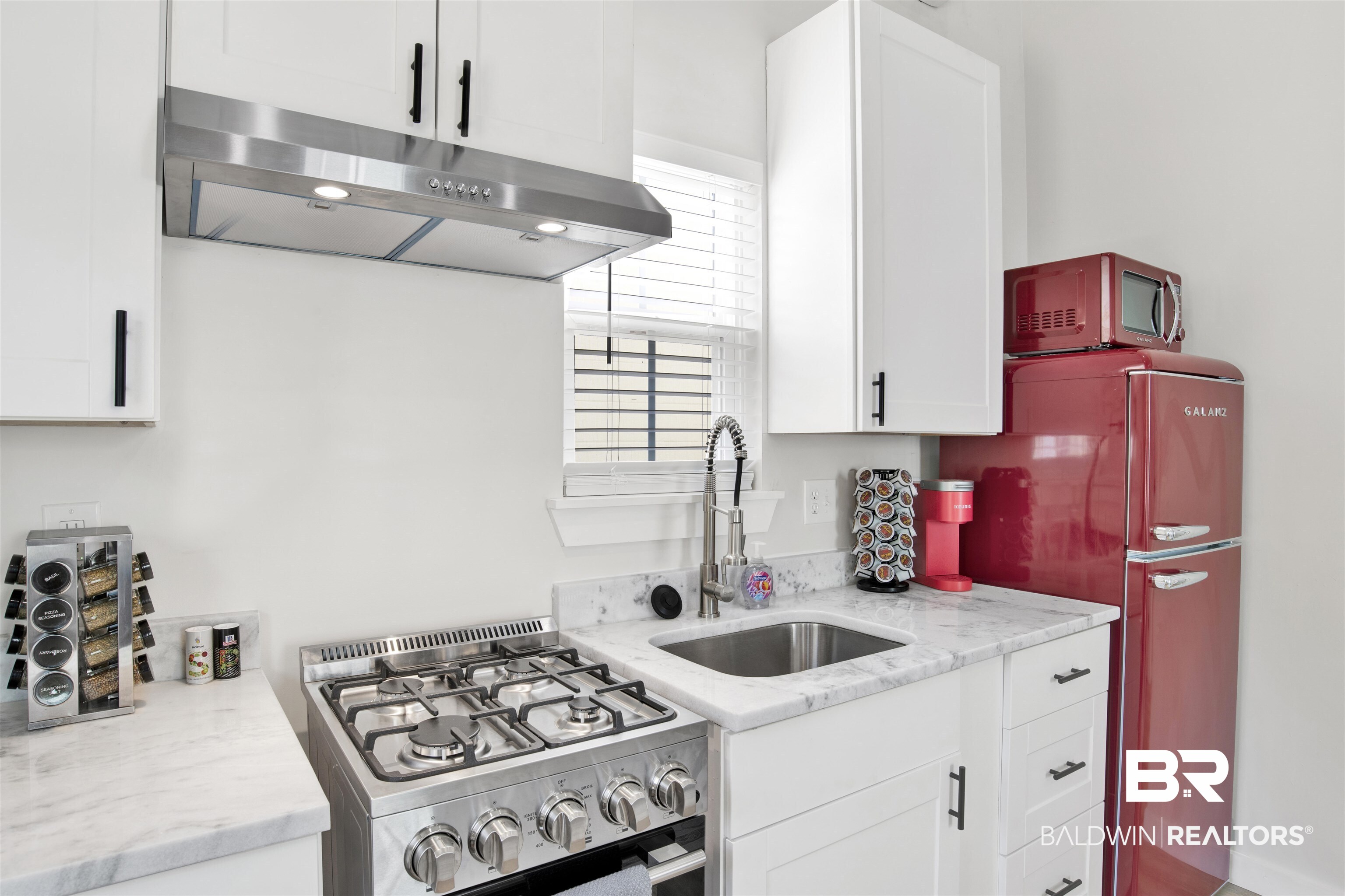 551 Congress Street Mobile, AL 36603 - Photo 11 of 19 Kitchen with stainless steel range with gas stovetop, light stone countertops, and white cabinets