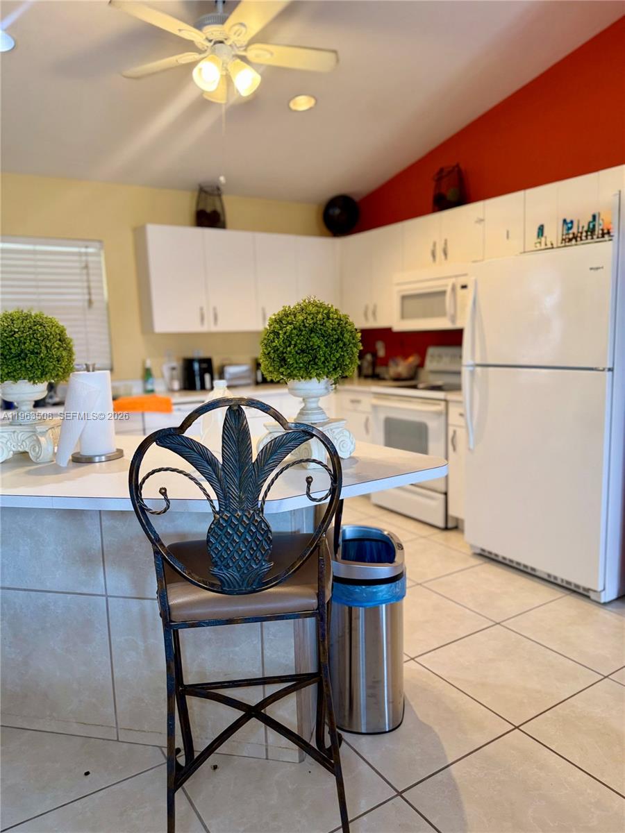 126 Zenith Circle Fort Myers, FL 33913 - Photo 6 of 24 a kitchen with a refrigerator a table chairs and a stove