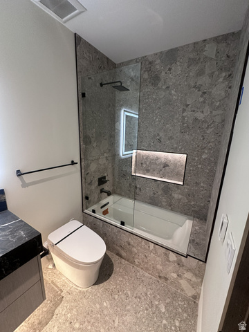 1918 Chimney Rock Road Heber City, UT 84032 - Photo 69 of 74 Contemporary bathroom featuring a black marble-topped vanity, grey patterned tile flooring, and a tub with a glass shower enclosure