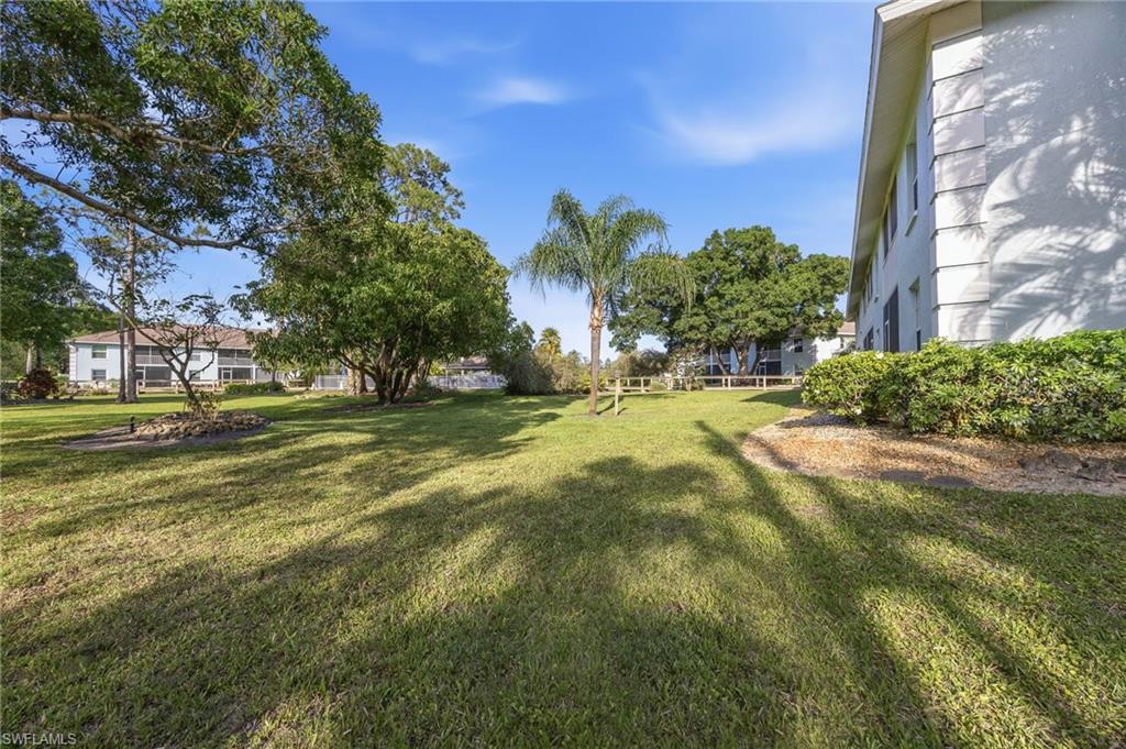 5737 Whitaker Road, Unit C101 Naples, FL 34112 - Photo 26 of 28 a swimming pool with trees in the background