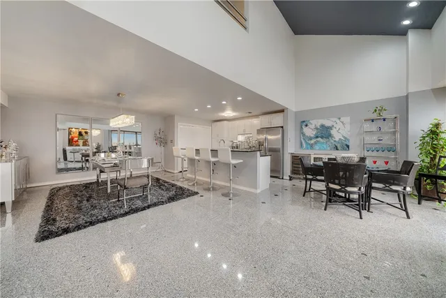 a kitchen with stainless steel appliances kitchen island granite countertop a refrigerator and cabinets