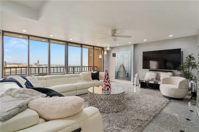 a living room with furniture a flat screen tv and a large window