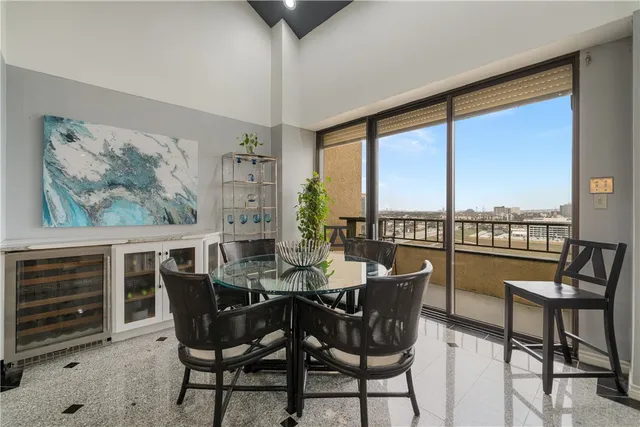 a dining room with furniture and large windows