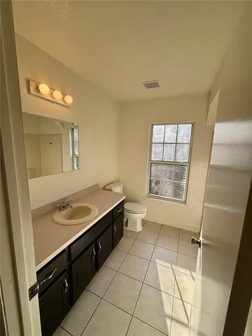 a bathroom with a granite countertop sink a toilet a mirror and a shower