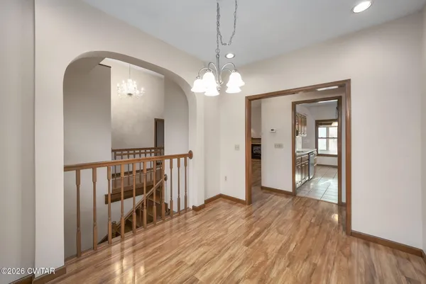 a view of a room with wooden floor staircase and a ceiling fan