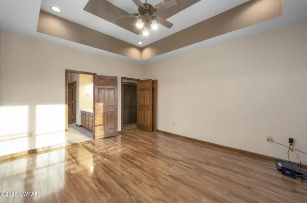 a view of an empty room with window and wooden floor