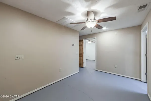 an empty room with a fan and a fan