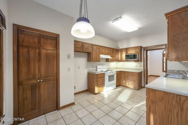 a large kitchen with a large counter top space appliances and cabinets