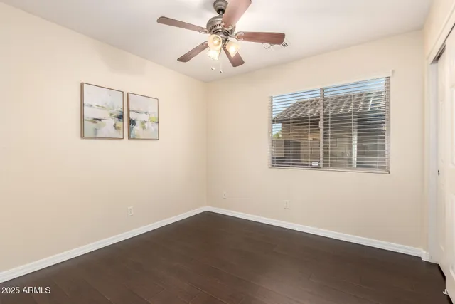 a view of an empty room with a window and a ceiling fan