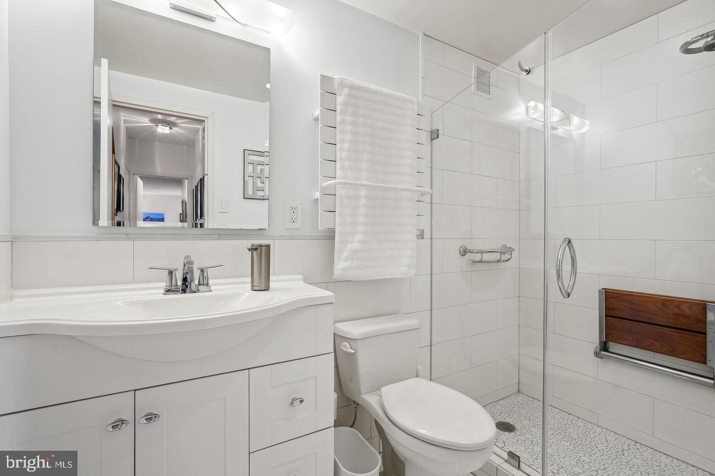 4141 North Henderson Road, Unit 611 Arlington, VA 22203 - Photo 13 of 30 a bathroom with a toilet a sink a mirror a vanity and shower
