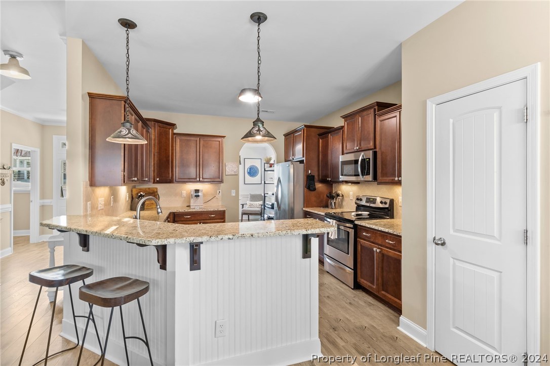 129 Warren Lake Road Aberdeen, NC 28315 - Photo 13 of 50 a kitchen with stainless steel appliances granite countertop a sink a stove and a refrigerator