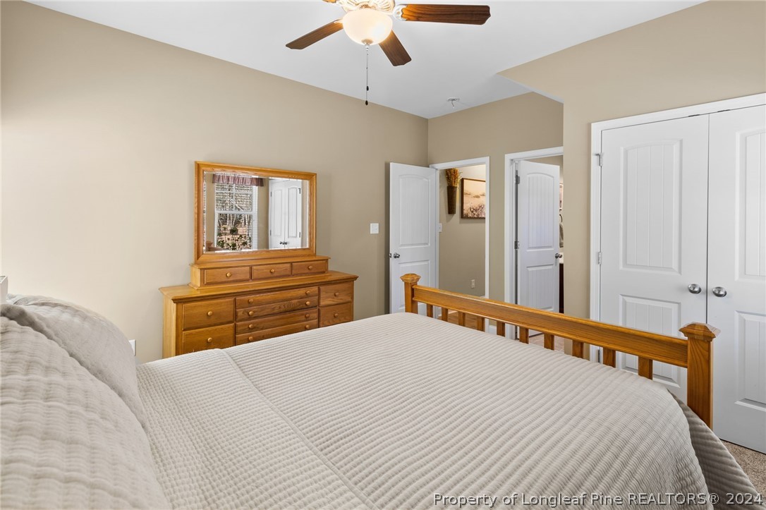 129 Warren Lake Road Aberdeen, NC 28315 - Photo 23 of 50 a bedroom with a bed and a chandelier